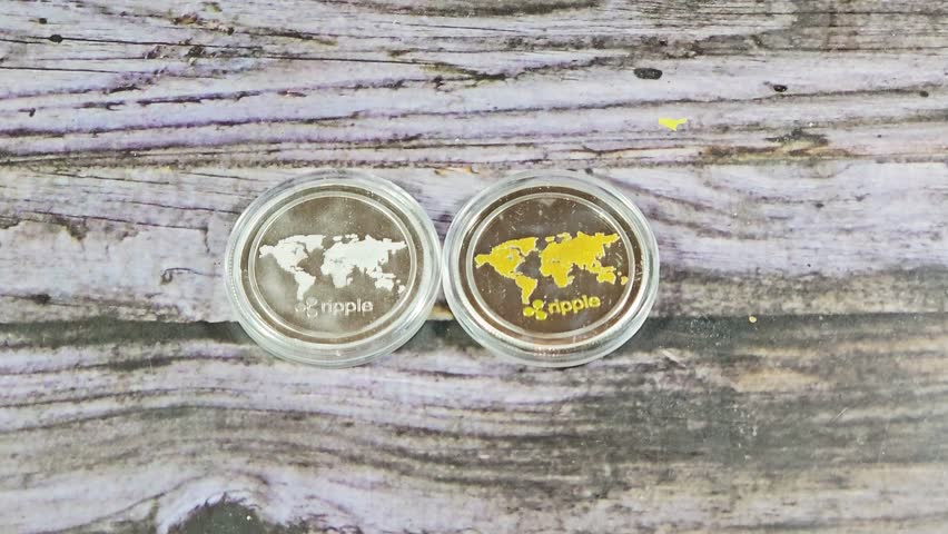 Silver and golden Physical Ripple XRP,  the native cryptocurrency of the XRP Ledger (XRPL), an open-source, decentralized blockchain technology, designed to facilitate fast cross-border payments