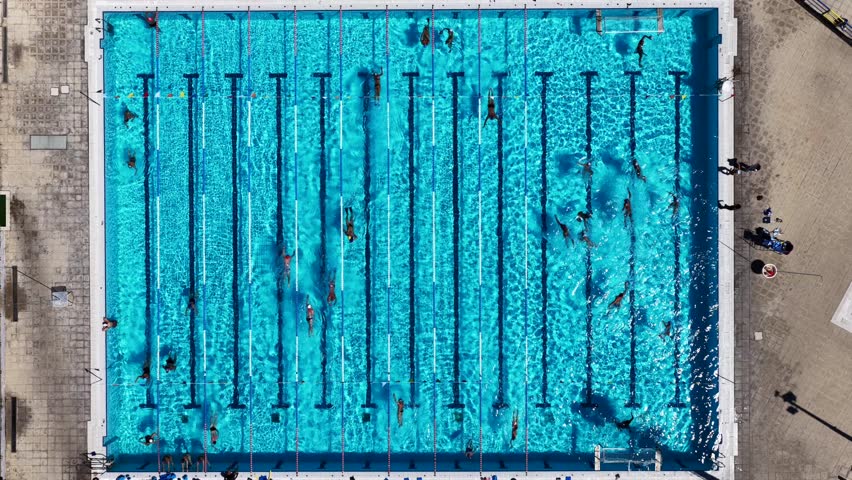 Aerial drone top down video of large swimming pool used for athletic competition during work out 
