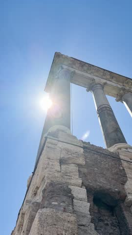 Panoramic aerial view of the Roman Forum in Rome featuring ancient columns, triumphal arches, temple ruins, the Vittoriano monument, and tourists under a clear blue sky.