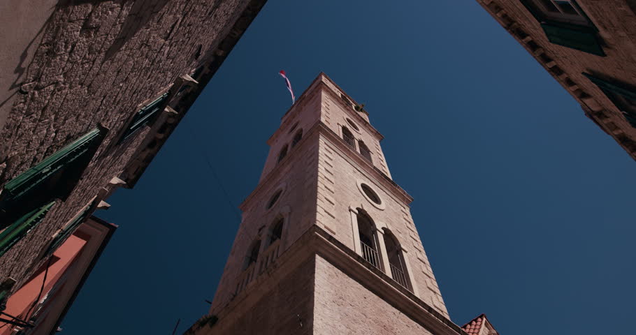 Historic stone clock tower viewed from a narrow street in the old town of Sibenik Croatia.