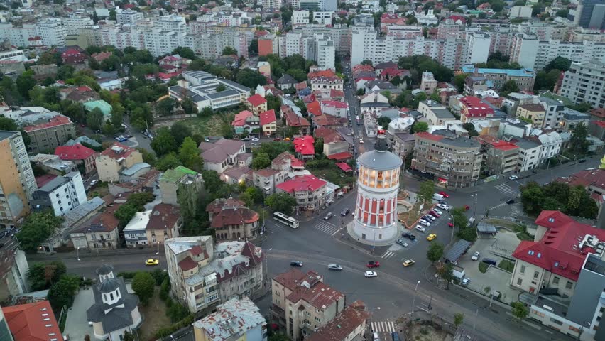 High angle daytime view of the historic Bucharest fire tower in Romania. Beautiful old circular brick architecture surrounded by urban city streets.
