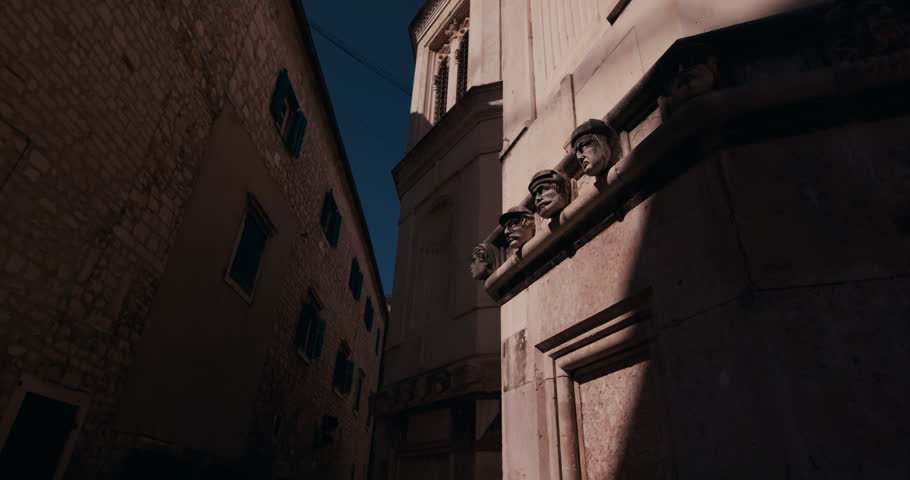 Close view of carved stone head sculptures on the exterior of St James Cathedral in Sibenik Croatia.