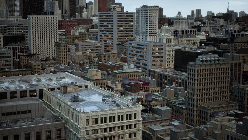 Slow panning camera movement over dense metropolitan cityscape showing rooftop details of office buildings under overcast sky in major American city district with residential towers in distance.