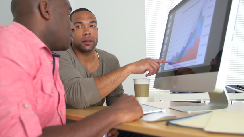 Two Happy Black Businessmen looking at data on computer