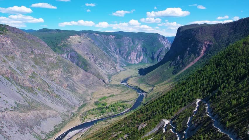 Sunlit canyon overlook with river winding through rocky valley