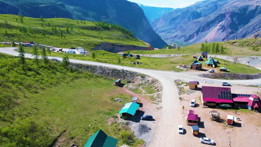 Aerial valley campsite with tents and vehicles