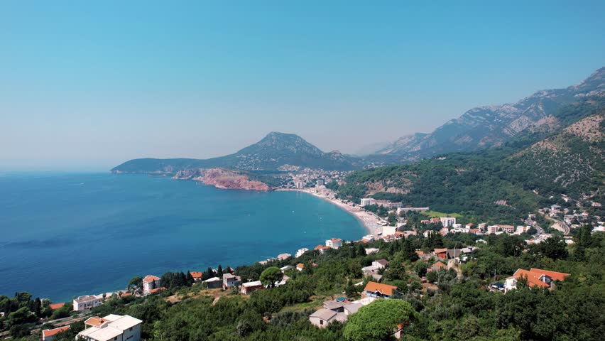 Aerial coastal bay landscape in Montenegro with mountains, sea, and hillside homes