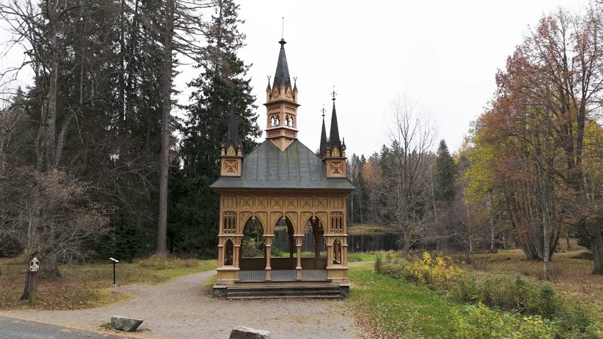 Aulanko Observation Tower rises above the forested hills, offering breathtaking views over vast Finnish lakes and endless natural landscapes. Nearby, a charming Gothic-style wooden pavilion overlooks a peaceful pond, creating a scene rich in romance and history. The ancient stone tower, adorned with architectural details and reached by a spiral staircase, reflects the elegance of a bygone era. From the summit, shimmering water reflections, rolling forests, and panoramic vistas reveal one of Finland’s most enchanting viewpoints.

