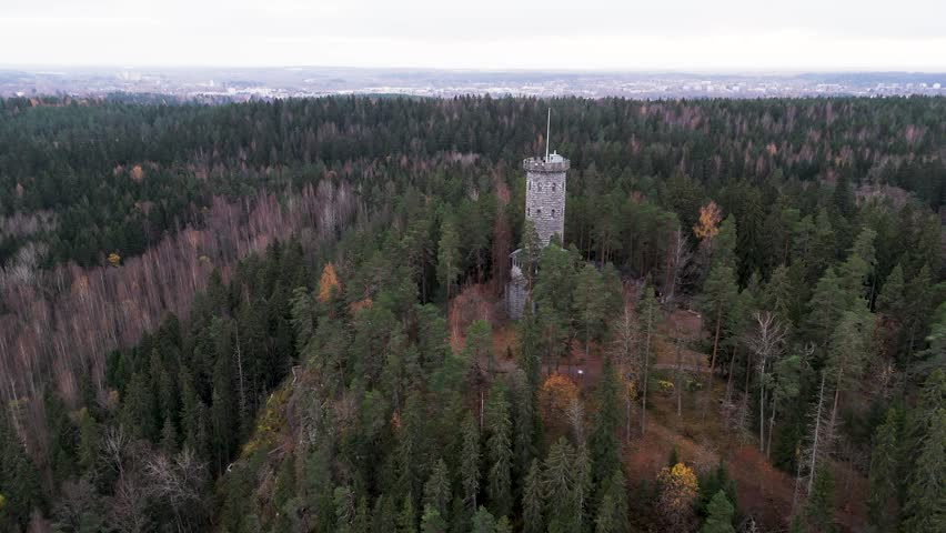 Aulanko Observation Tower rises above the forested hills, offering breathtaking views over vast Finnish lakes and endless natural landscapes. Nearby, a charming Gothic-style wooden pavilion overlooks a peaceful pond, creating a scene rich in romance and history. The ancient stone tower, adorned with architectural details and reached by a spiral staircase, reflects the elegance of a bygone era. From the summit, shimmering water reflections, rolling forests, and panoramic vistas reveal one of Finland’s most enchanting viewpoints.

