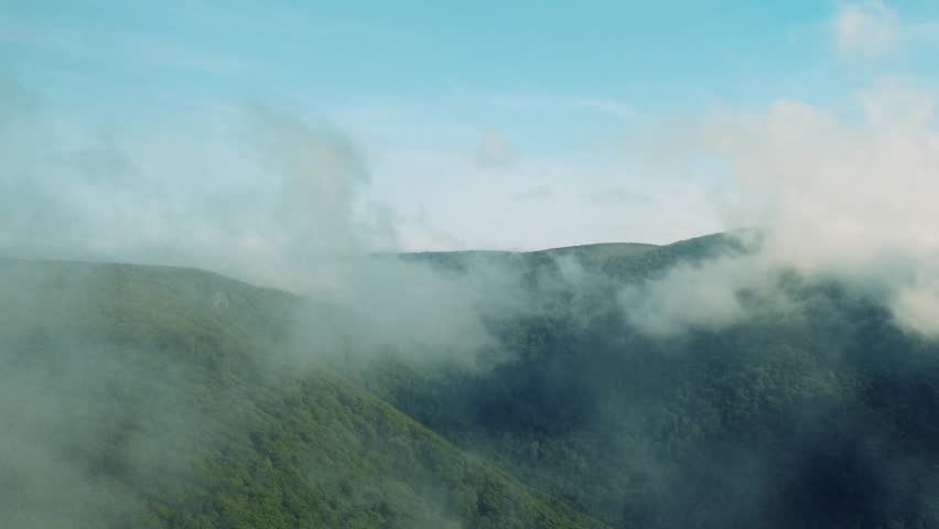 aerial through clouds on top of the mountain