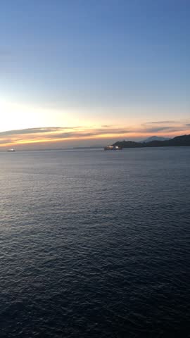 A serene sunset over the ocean, viewed from a ship