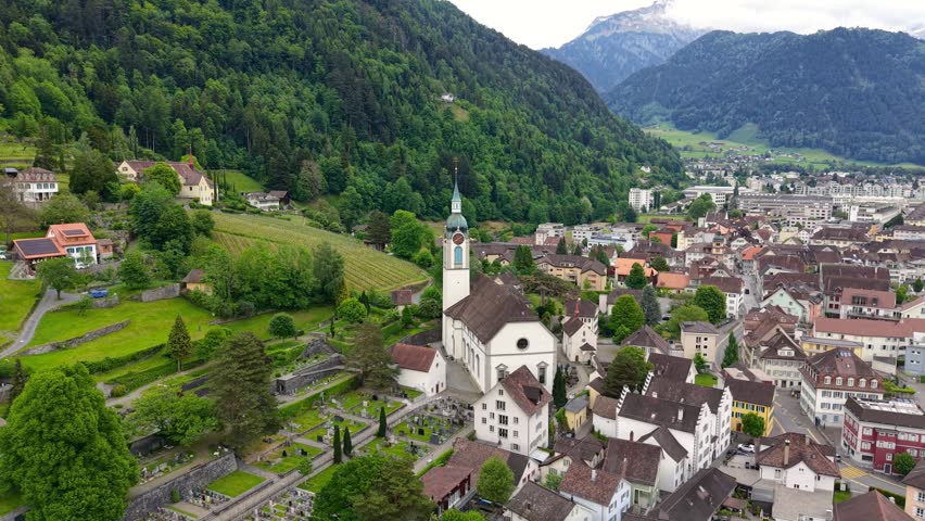 Scenic aerial footage of Walenstadt, a charming Swiss town with a prominent church and cemetery.