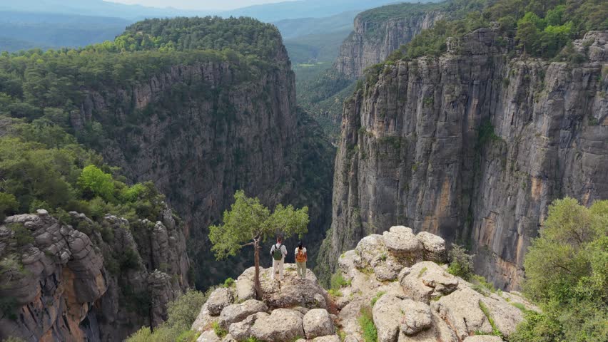 A of men and women standing at the majestic Tazi Canyon in Antalya, Turkey. Perfect for adventure seekers, this stunning natural wonder invites hikers to explore its beauty and charm.