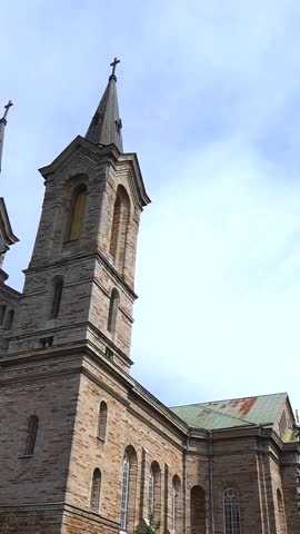 Low angle view of the historic Kaarli Church, a prominent landmark in Tallinn, Estonia, showcasing its neo Romanesque architecture with twin towers against a bright blue summer sky