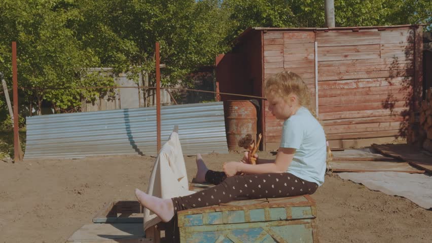 A child playing with a doll in nature, playing with a doll, a girl with a doll