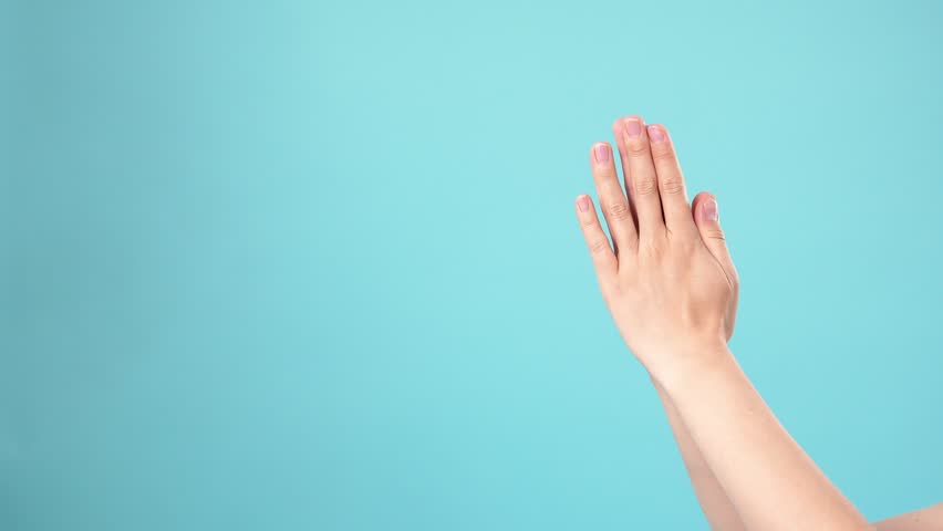 Close up of hands clapping against a blue background