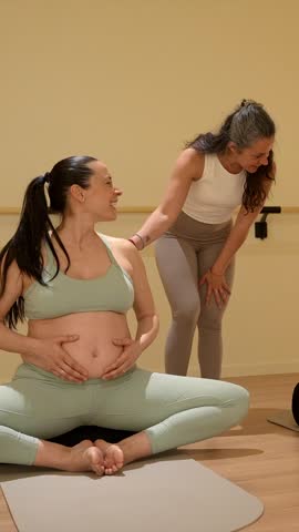 Yoga instructor coaching and supporting a group of pregnant women during a prenatal fitness class, fostering a sense of community and well being for expectant mothers in a calm studio