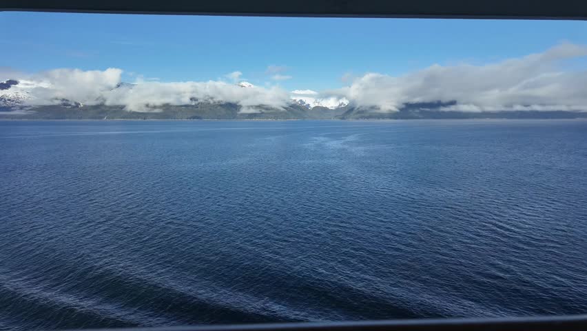 Alaskan cruise timelapse right off cruise ship balcony during calm seas, mountains and low clouds