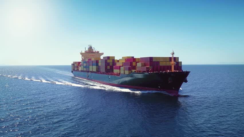 Aerial tracking view of a industrial container cargo ship traveling over the ocean as a concept for transport and shipping
