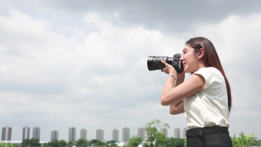 Professional Female Photographer Reviewing Photos on Digital Camera Outdoors