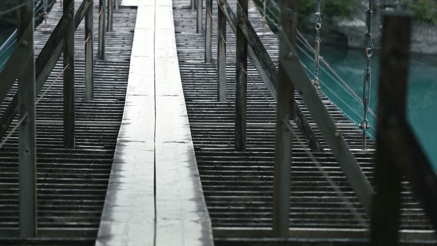 People crossing the "Dream Suspension Bridge" in Sumatakyo Gorge, as the wooden suspension bridge sways.
