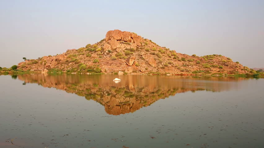 Rocky hill reflecting in water