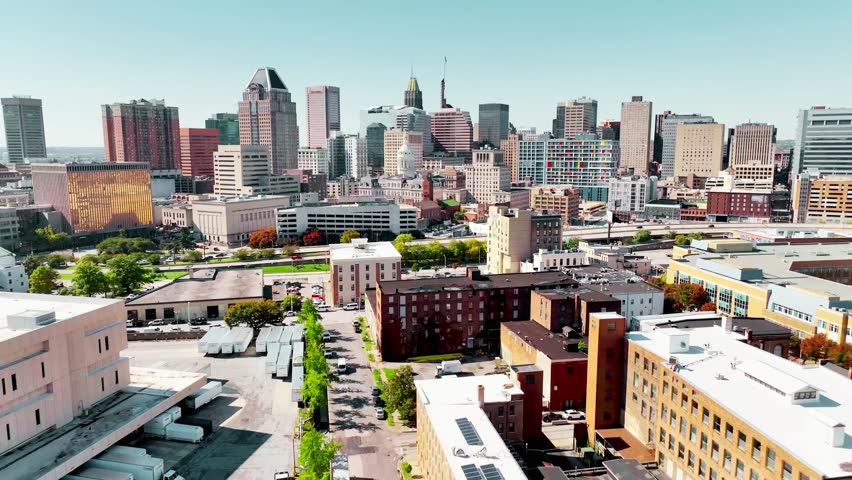 Aerial push-in of Baltimore, Maryland skyline showcasing downtown skyscrapers, waterfront harbor, and urban cityscape under clear skies. June 6, 2025 highlights the vibrant East Coast metropolitan atmosphere.