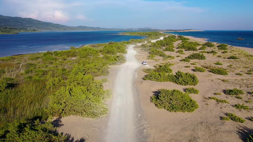 Road on a land strip between Korission Lake coastal lagoon and Ionian Sea on Corfu Island, Greece, 4k