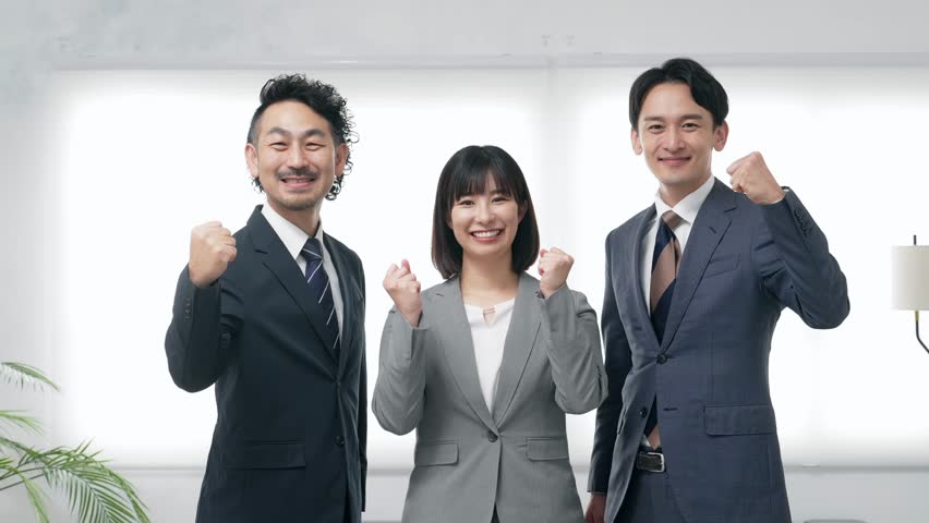 A group of business people making victory poses in the office.