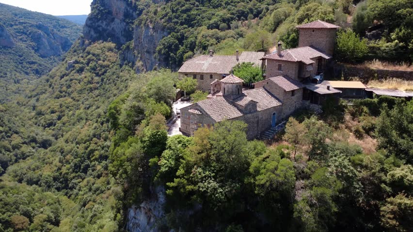 Inside a deep gorge with dense Mediterranean vegetation stands the historic and isolated Orthodox Christian Monastery of the Philosopher in Greece, Europe.