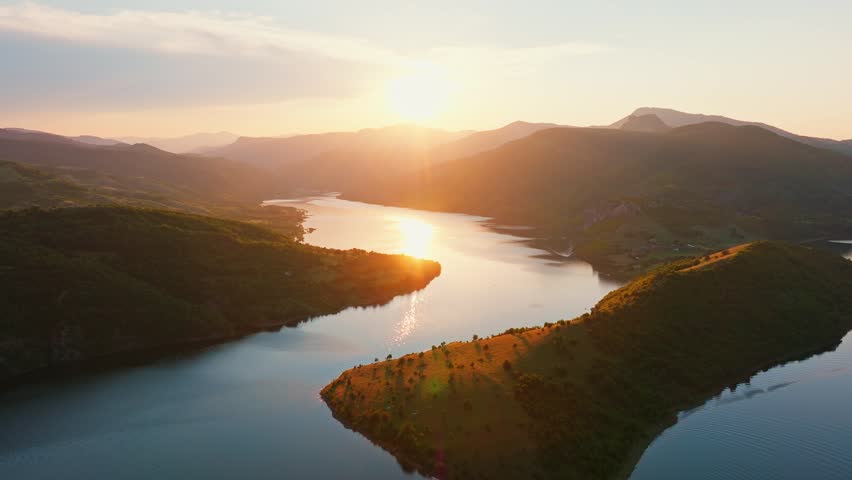 Kardzhali reservoir sunset golden hour aerial drone Bulgaria Rhodope mountains winding lake reflection warm light orange sky nature landscape slow motion travel scenic Balkans overview