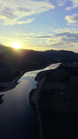Vertical drone footage of the Mekong River flowing through lush tropical landscapes and rural countryside in Vietnam.