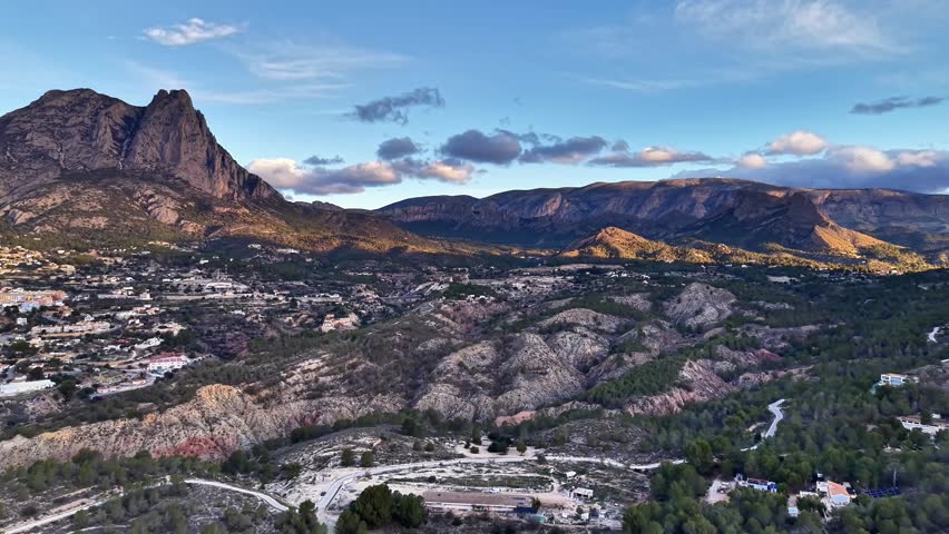 Rocky Ridge With Broad Valley View And Distant Jagged Peak, Winding Trail Visible, Warm Late Afternoon Light