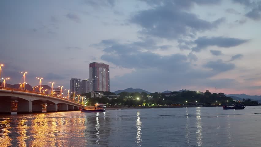 Dusk City Skyline with Illuminated Bridge and Calm River Reflections