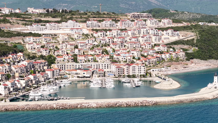 Lustica Bay, Montenegro. Drone Shot of Luxury Apartment Buildings and Marina on Sunny Day
