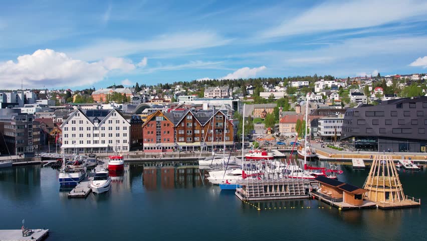 Troms Harbour features vibrant buildings and calm waters, showcasing the stunning landscape of the northern Norwegian city. This picturesque area is perfect for walking and sightseeing.