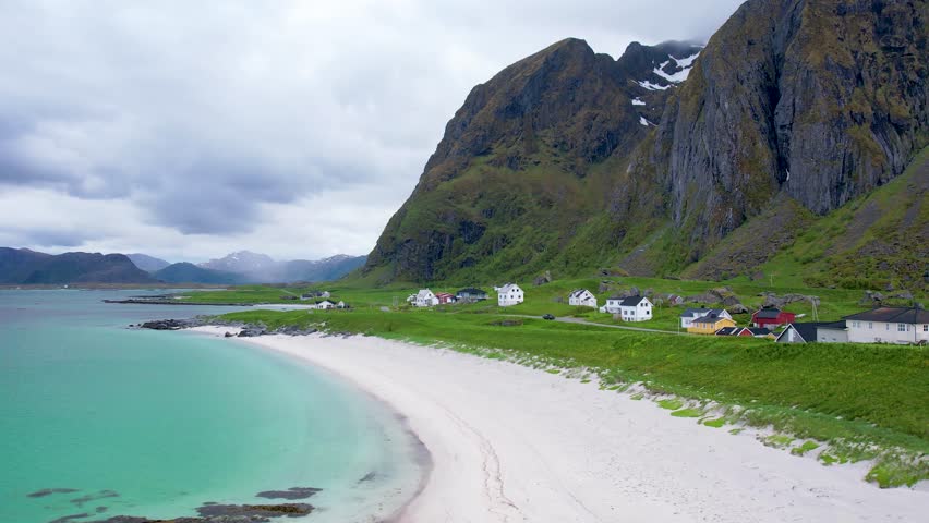 Aerial drone view of Lofoten Islands in Norway, featuring beautiful landscapes on Eggum Beach, white sand, clear water and dramatic mountains near the shore. Experience the natural beauty