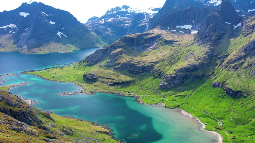 Aerial drone view of Lofoten Islands in Norway, featuring beautiful landscapes on Vindstad Beach near Reine, white sand clear water and dramatic mountains near the shore. Experience the natural beauty