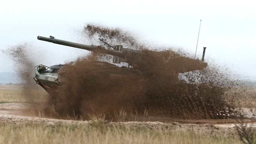Main Battle Tank Advancing Through Dusty Terrain.