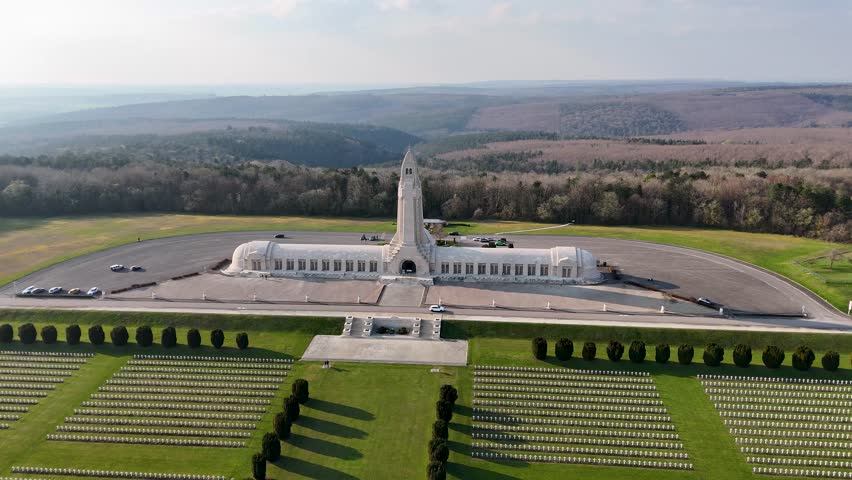 Drone view of Douaumont Ossuary and French military cemetery near Verdun, Meuse, France, with rows of white crosses and memorial grounds.