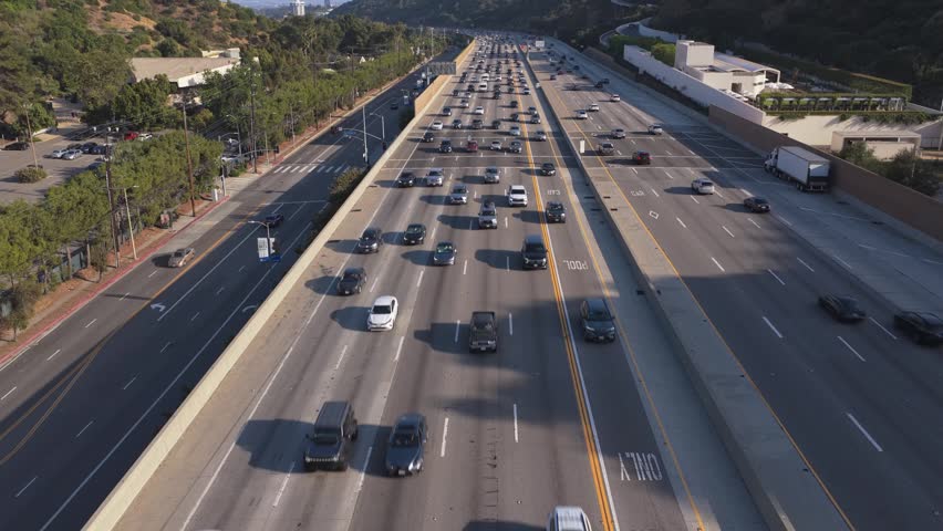 Heavy rush hour traffic congestion on freeway in Los Angeles, California with vehicles driving through Sepulveda Pass and Santa Monica Mountains