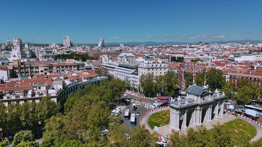 Drone view of Puerta de Alcalá with central Madrid rooftops and towers behind