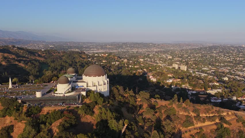 Griffith Observatory overlooking Los Angeles downtown skyline with Hollywood Hills and Griffith Park landscape on Mount Hollywood in Southern California