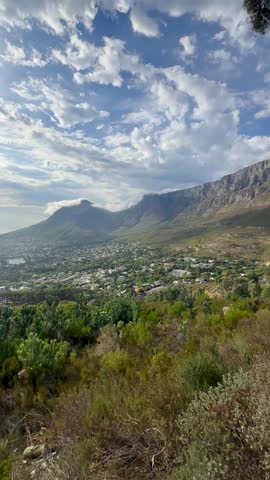 Pan right view of Table Mountain rising prominently above the Cape Town suburbs in South Africa.