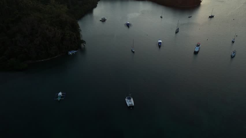 Aerial view of anchored boats floating in a quiet Puerto Galera cove