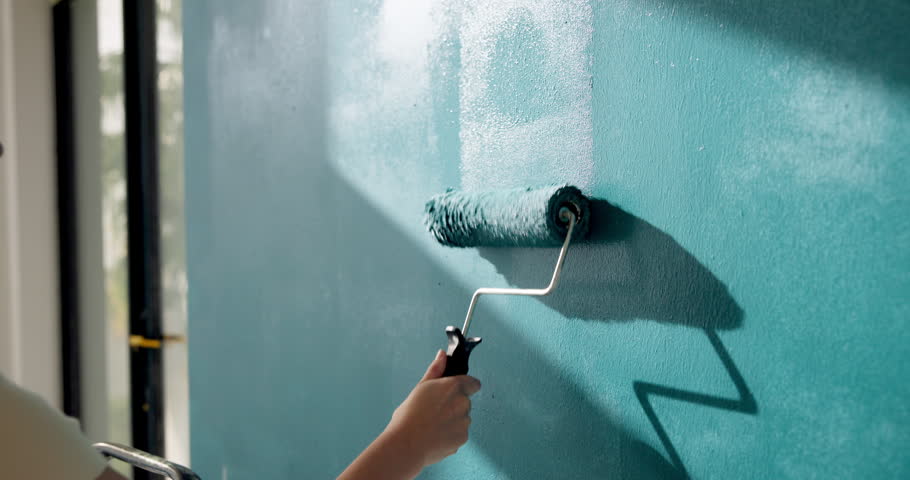 Person, hand and paint for renovation in home, upgrade and interior design with improvement. Paintbrush, equipment and remodeling with DIY project, maintenance and color for wall and process