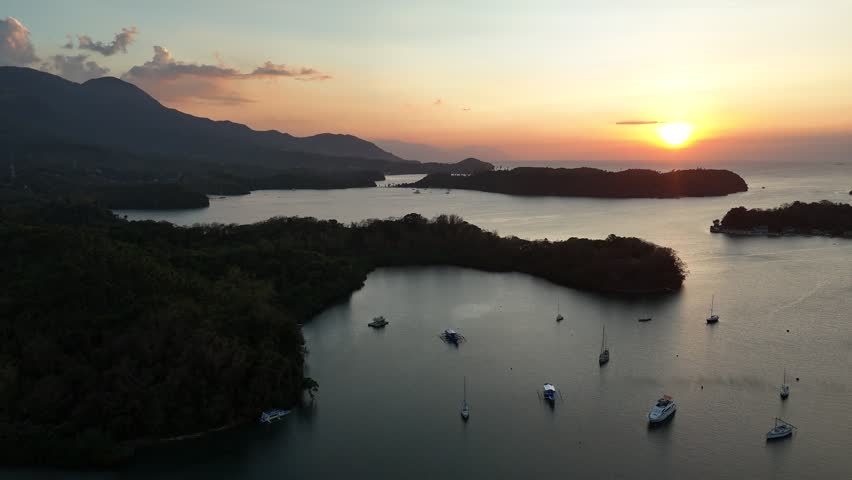 Drone view of Puerto Galera coves and anchored boats at sunset