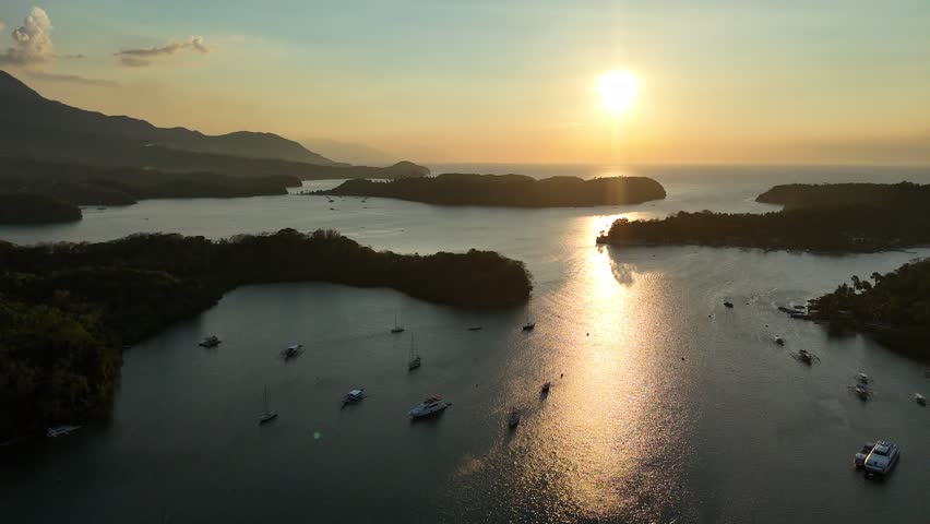 Golden sunset over Puerto Galera bay with boats scattered across calm water