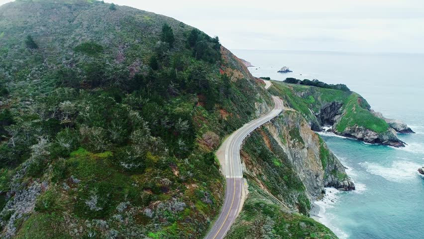 Winding highway follows rugged shoreline through dramatic California scenery