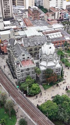 Aerial view of the Rafael Uribe Uribe Palace of Culture in Medellin, Colombia. Cinematic drone shot of the iconic Gothic Revival landmark and Plaza Botero.